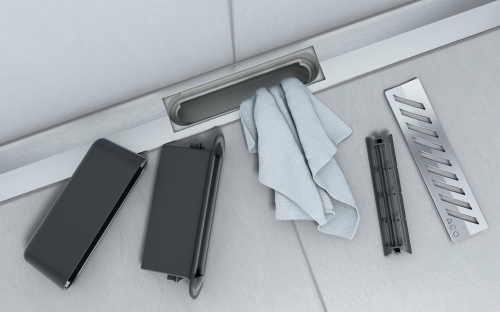 Einfache Reinigung: Die Duschrinne ACO ShowerDrain SE+ ist vollständig zugänglich konstruiert. Der Rost lässt sich durch antippen des Logos anheben und werkzeuglos entnehmen. Sowohl das Haarsieb als auch der zweiteilige Geruchsverschluss sind schnell entnehmbar, der Zugang zur Rohrleitung ist dadurch frei.